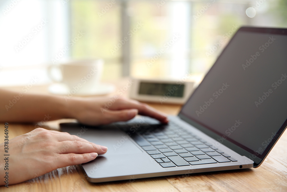 Woman working with modern laptop at wooden table, closeup Woman working with modern laptop at wooden table, closeup