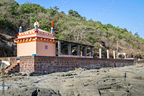 Colorful temple of goddess Uma Maheshwari on rocky shore. photo