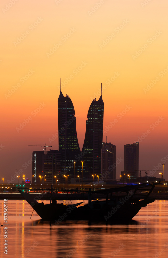 MANAMA , BAHRAIN - DECEMBER 02: Bahrain Financial Harbour  and traditional dhow during sunset on December 02, 2019, Bahrain