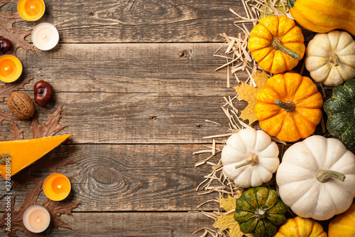 Thanksgiving background with decorative pumpkins, pumpkin pies and candles