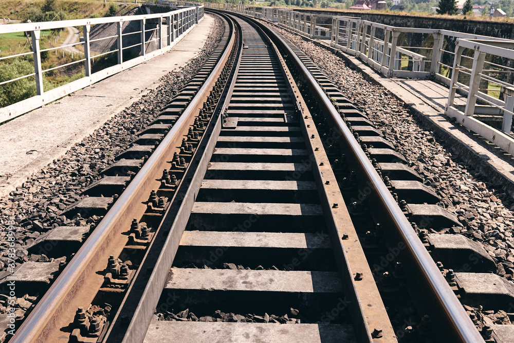 Train rails in country landscape. Railroad tracks at sunset time. Local travel concept Train rails in country landscape. Railroad tracks at sunset time. Local travel concept
