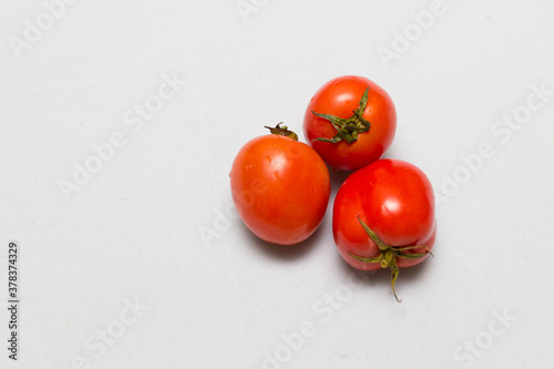 juicy red tomatoes in table cloth . caro background 