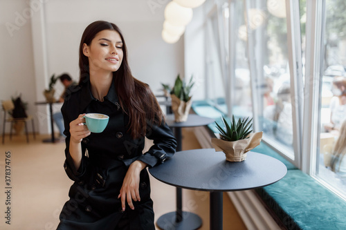beautiful girl in a coffee shop with a cup of coffee © Дмитрий Скорина