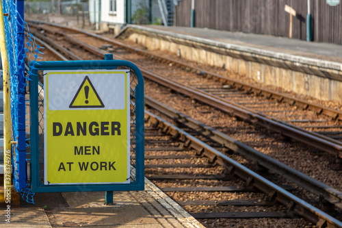 A sign next to train tracks reading Danger men at work