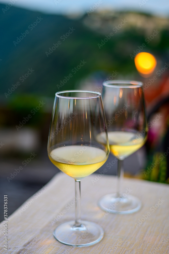 Two glasses of cold dry white wine served outdoor in cafe at night in Italy