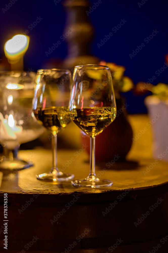 Two glasses of cold dry white wine served outdoor in cafe at night in Italy