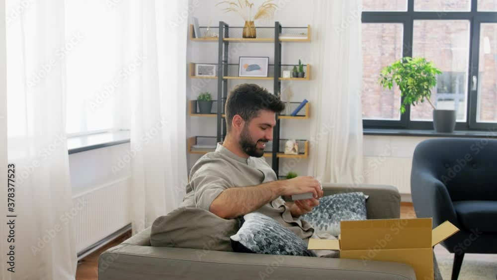 mail delivery, shipment and people concept - happy man opening parcel box at home mail delivery, shipment and people concept - happy man opening parcel box at home