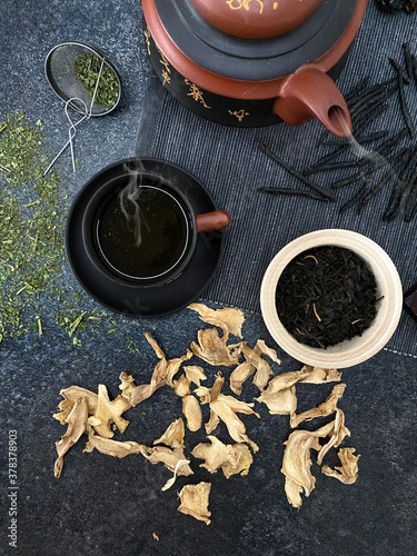 Healthy tea with ginger and mint. A cup of hot warming tea. A teapot of Chinese tea. Steam from hot tea.