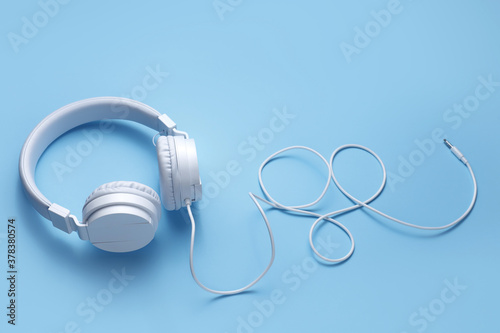 White headphone on blue background. Music concept.
