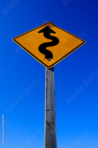 Curves Ahead Roadsign Road Sign Yellow on Blue Sky