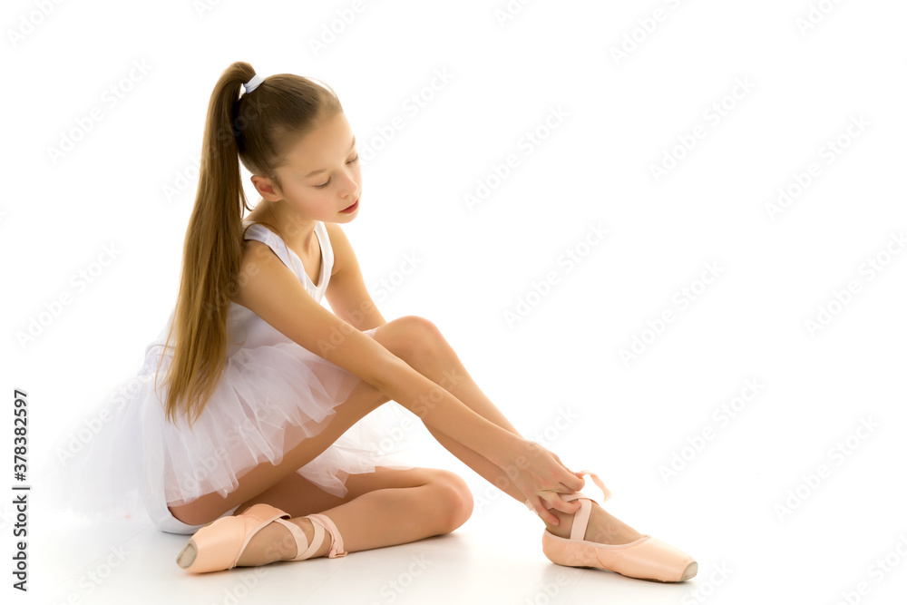 Girl ballerina puts on pointe shoes. The concept of dancing. Girl ballerina puts on pointe shoes. The concept of dancing.