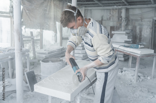 The master engraves the tombstone. Stone processing