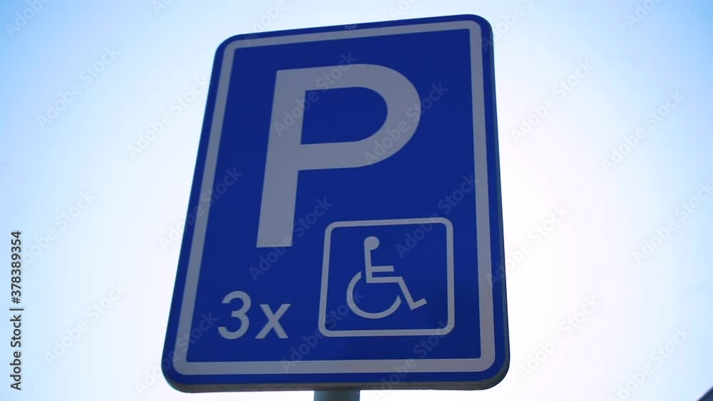 Wheelchair parking sign on the background of the bright sun. Special places for cars belonging to disabled people. Wheelchair parking sign on the background of the bright sun. Special places for cars belonging to disabled people.