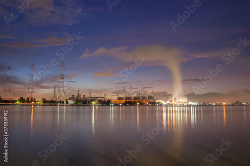 power plant reflection on river againts sky