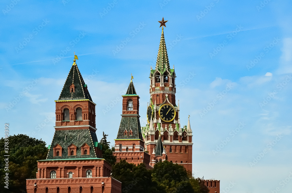 Spasskaya Tower of Moscow Kremlin against background of blue sky. Famous chimes are the main clock of Russia. Sights of Russia, a historical building, symbol of the country. Spasskaya Tower of Moscow Kremlin against background of blue sky. Famous chimes are the main clock of Russia. Sights of Russia, a historical building, symbol of the country.