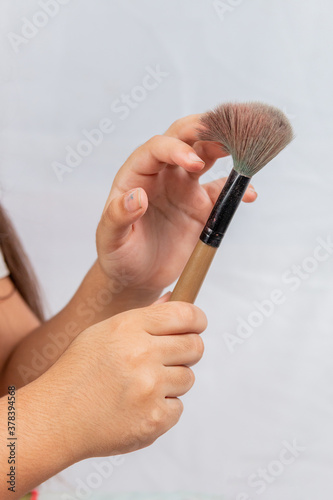 child with makeup brushes with white background in rio de janeiro
