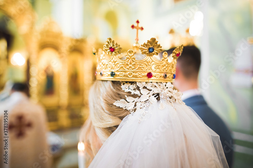 Bride and groom holding candles in church photo