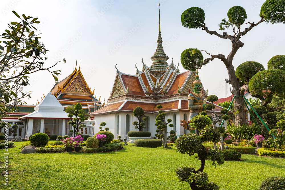 Buddhist Temple wat Pho and ornate topiary trees in Bangkok, Thailand