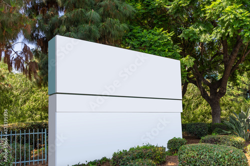 Blank outdoor large signage surrounded by in a green garden