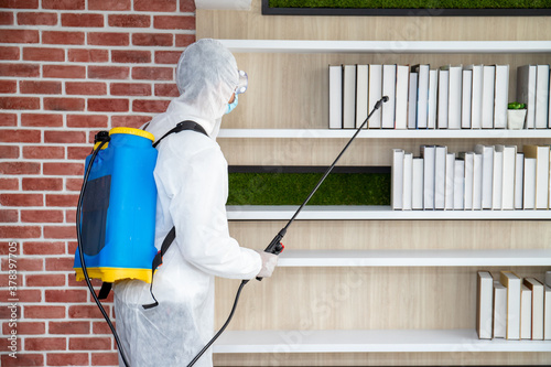 Male medical staff wearing PPE uniforms to prevent COVID-19 from using a nebulizer. And use chemicals to disinfect at the library, reading room, to prevent the risk of coronavirus outbreak.