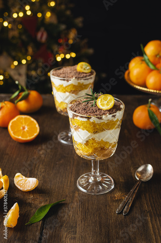 Process of preparation christmas layered dessert, no bake cheesecake or trifle with tangerines and chocolate