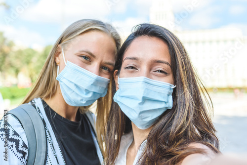 Self portrait of an indian woman with a caucasian friend, both with surgical blue masks