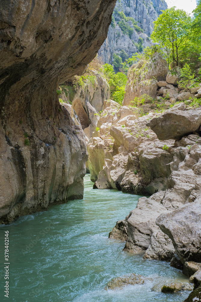 rivière turquoise sous une paroi rocheuse, coulant au fond d'un canyon