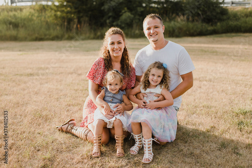 Portrait of smiling parents with two daughters on a meadow