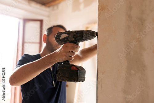 Construction worker using drill at a wall photo