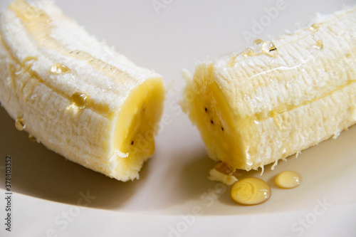 Peeled banana, served on a plate covered with fresh honey, organic product, nutrition to strengthen defenses and prevent COVD 29 or Coronavirus. photo