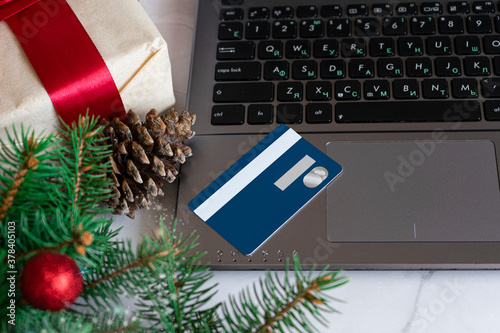Christmas shopping online with a credit card for the Christmas holidays. Black Friday. Blue credit card. Notepad, Christmas decorations, gifts, white marble background. © Татьяна Григорьева