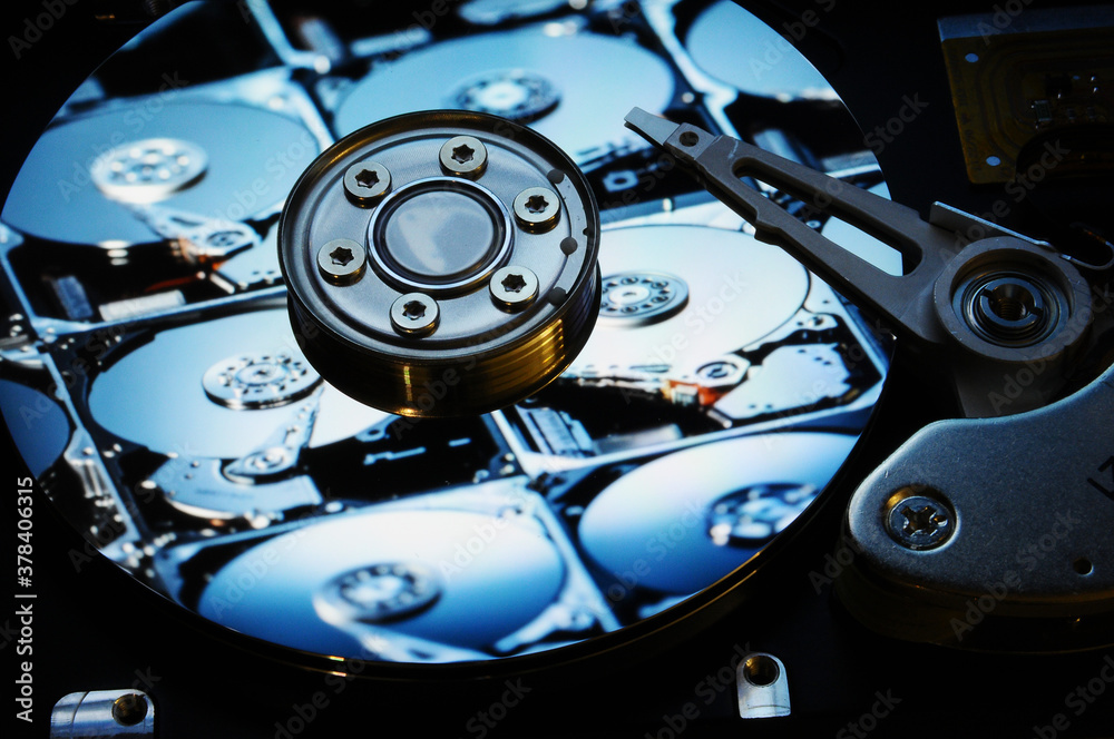Closeup of open Computer Hard Disk Drive with other Hard Drives reflected on the disc surface. Wallpaper Background. Closeup of open Computer Hard Disk Drive with other Hard Drives reflected on the disc surface. Wallpaper Background.