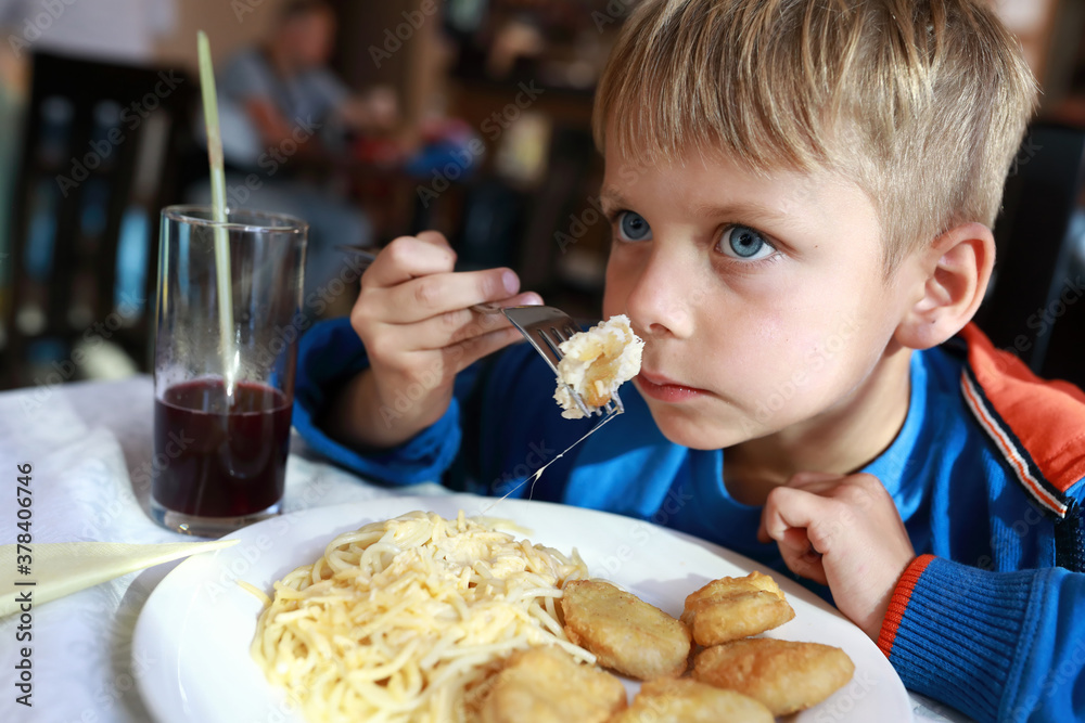 Boy eating nuggets with spaghetti Boy eating nuggets with spaghetti