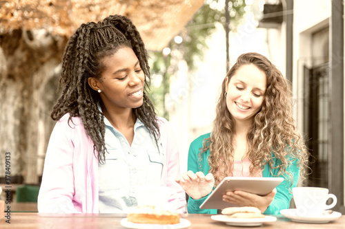 Two girlfriends watch the tablet at the Coffee Bakery shop