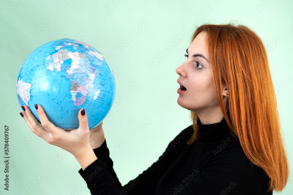 Portrait of a sad worried young woman holding geographic globe of the world in her hands. Travel destination and planet protection concept. Portrait of a sad worried young woman holding geographic globe of the world in her hands. Travel destination and planet protection concept.