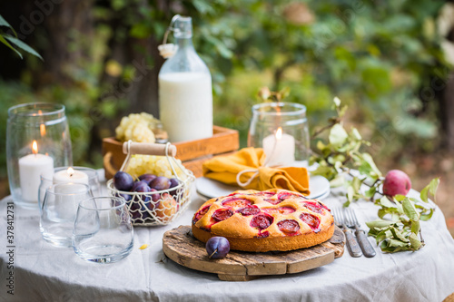 Traditional homemade plum cake or pie with summer table setting