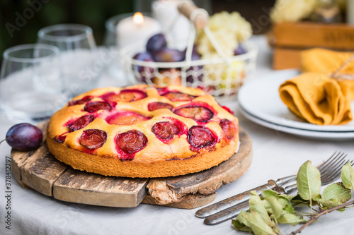 Traditional homemade plum cake or pie with summer table setting