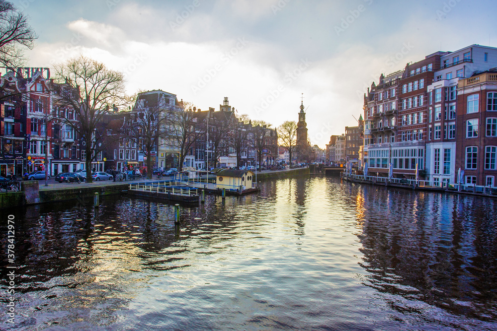 Idyllic view on Amsterdam : water in canals and  sunset sky and awe medieval architecture