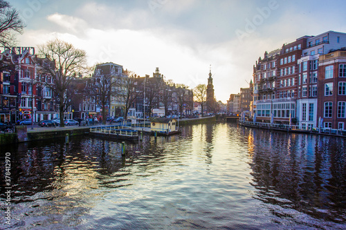 Obraz na plátně Idyllic view on Amsterdam : water in canals and  sunset sky and awe medieval arc