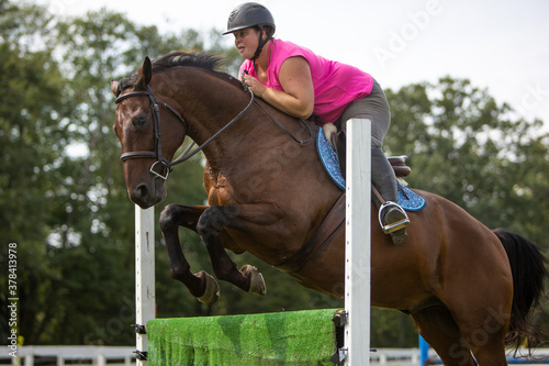 Horse and rider jumping a fence.