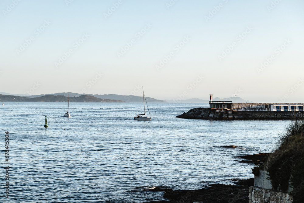 Small boat sailing back to port on a calm clear evening in the Rias Baixas in Galicia, Spain.