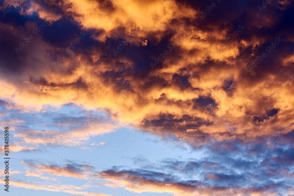 Orange sunset sky with large cumulus clouds