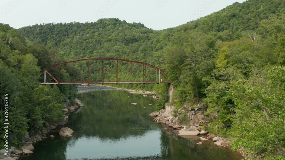 Steady flight of drone in aerial view towards 1912 historic metal truss Jenkinsburg Bridge near Mt Nebo and Morgantown over Cheat River Steady flight of drone in aerial view towards 1912 historic metal truss Jenkinsburg Bridge near Mt Nebo and Morgantown over Cheat River