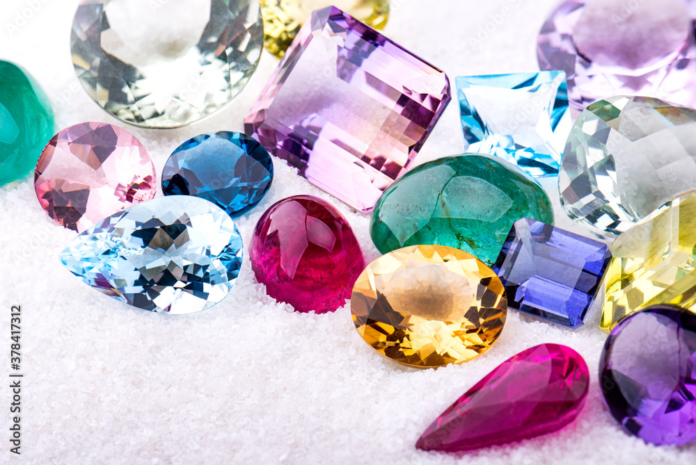 Group of gemstones on white sand.