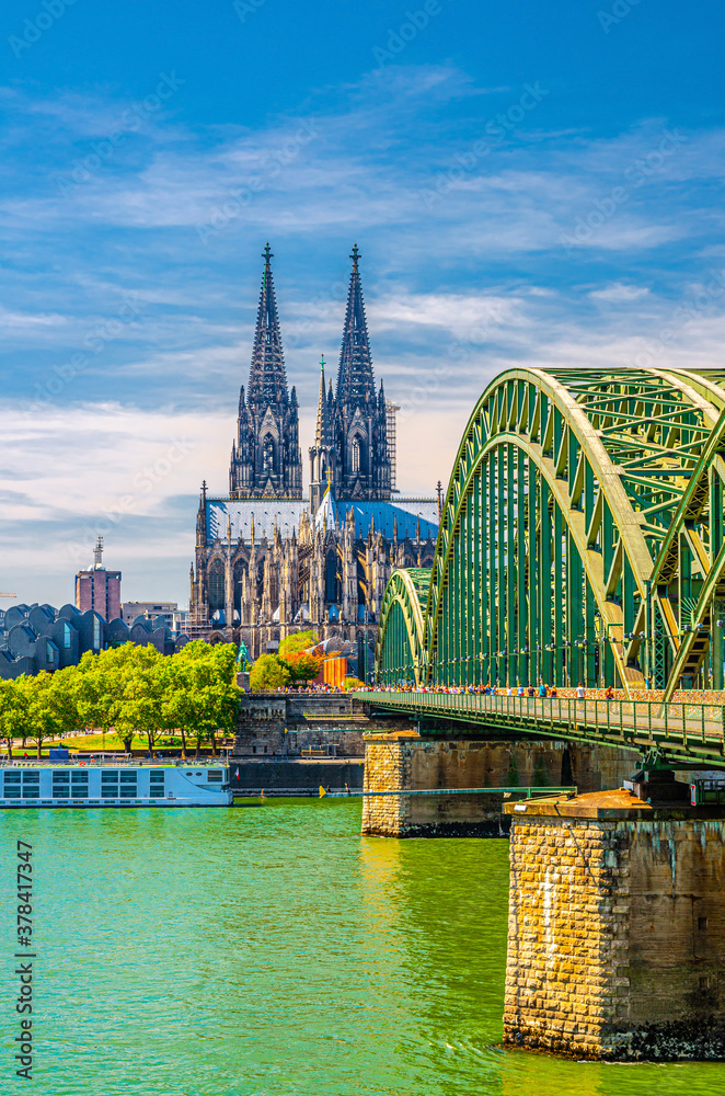 Cologne historical city centre with Cologne Cathedral Roman Catholic Church Saint Peter gothic style building, Hohenzollern Bridge across Rhine river, vertical view, North Rhine-Westphalia, Germany