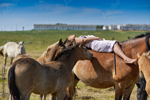 A young girl rides a horse lying down. © shymar27