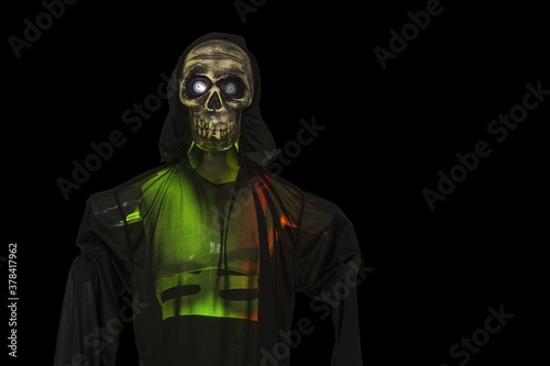 Close up view of green lighted skeleton figure on black background. Halloween concept. 