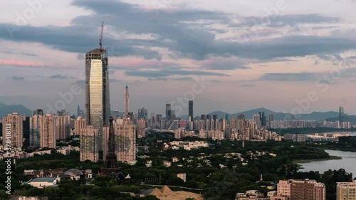Tall buildings stand in bristly flourishing city riverside scenery setting sun