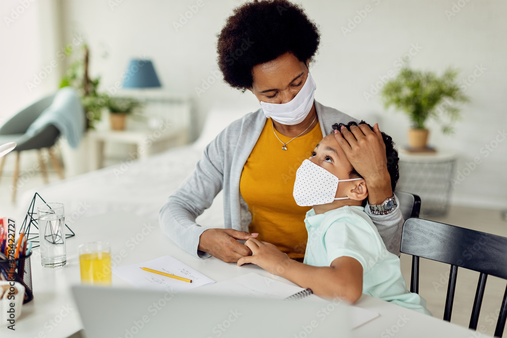 Caring black mother consoling her son while homeschooling during coronavirus pandemic. Caring black mother consoling her son while homeschooling during coronavirus pandemic.