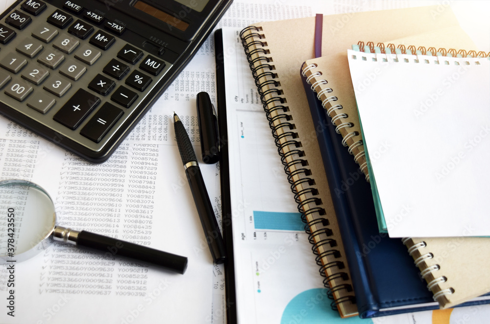 Business documents on an office desk with a calculator and pencil as a business concept of a workspace. With cloud exposure Business documents on an office desk with a calculator and pencil as a business concept of a workspace. With cloud exposure